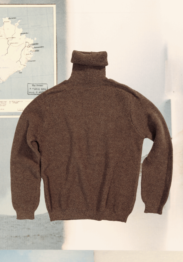 A brown turtleneck sweater with a relaxed fit, featuring a textured knit material, laid against a backdrop of a vintage map.