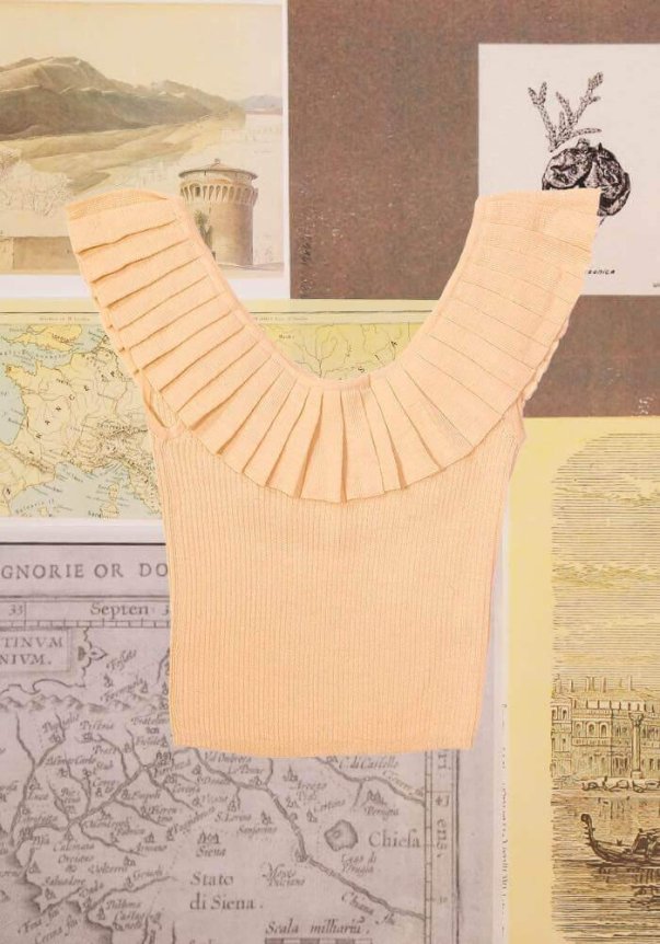 A peach-colored ribbed knit top with a pleated ruffle V-neck design, set against a backdrop of vintage maps and illustrations.