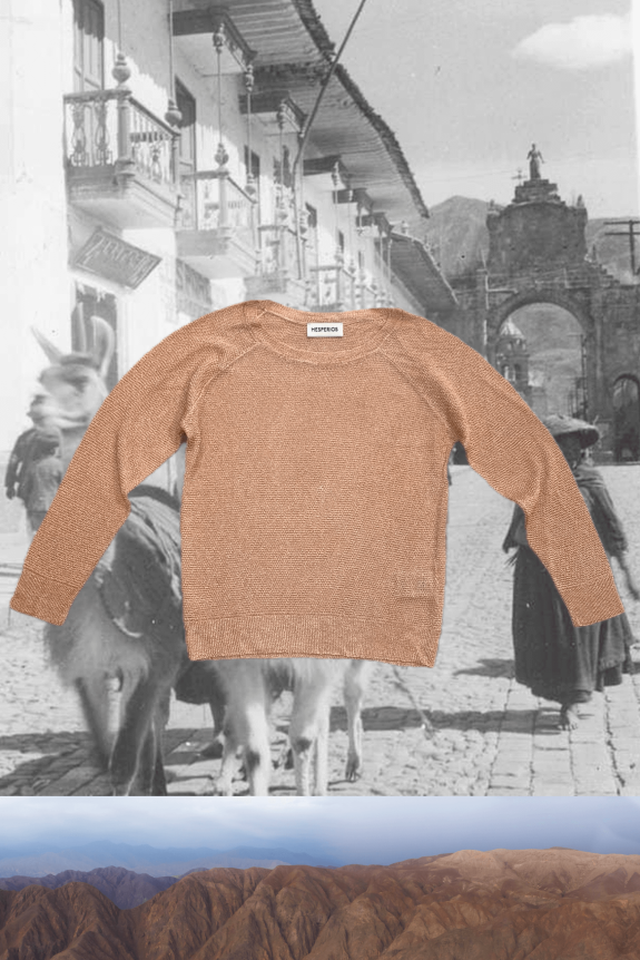 A camel-colored knit sweater with long sleeves and a relaxed fit, set against a black-and-white historical street scene and a mountainous landscape.