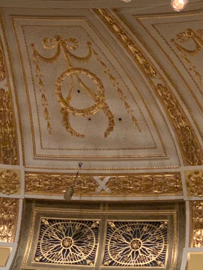 A ceiling with ornate gold decorative designs and intricate patterns.