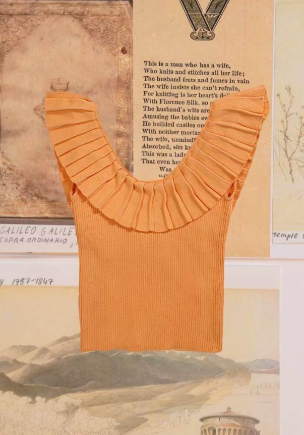 A peach-colored, ribbed sleeveless top with a wide ruffled neckline set against a vintage backdrop of text and illustrations.