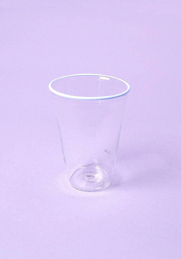A clear plastic cup on a lavender background.