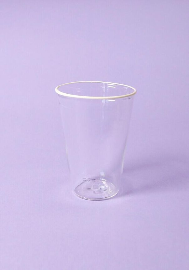 A transparent plastic cup on a light purple background.