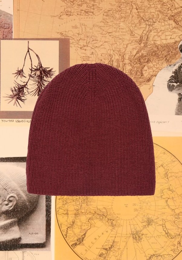 A black ribbed knit beanie against a background of vintage maps and diagrams.
