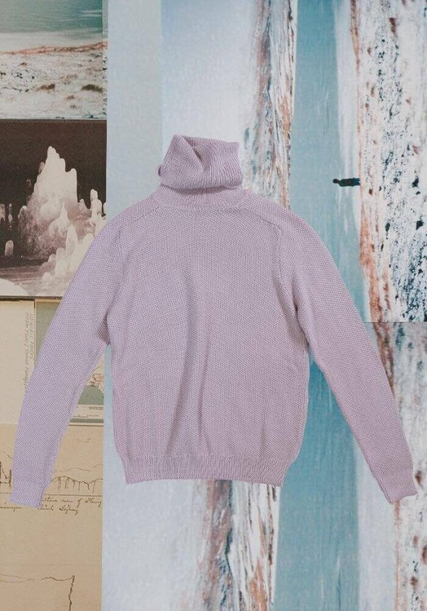 A lavender knit turtleneck sweater with a relaxed fit is displayed against a collage of icy and abstract background images.