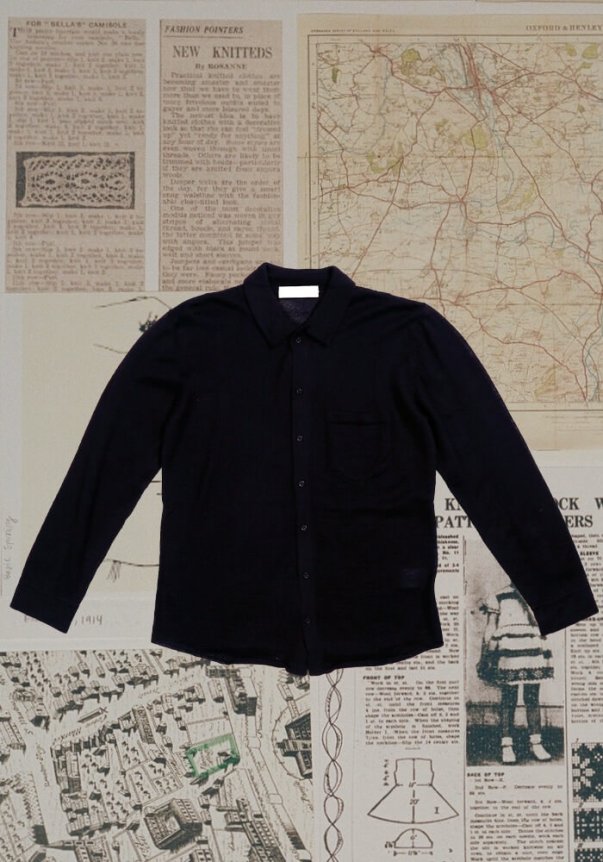 Navy blue long-sleeve button-up shirt, classic fit with a chest pocket, set against a background of vintage maps and newspaper clippings.
