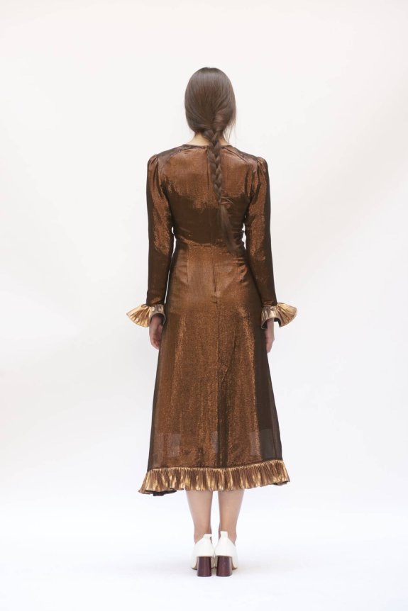 A bronze, shimmering, long-sleeve, mid-length dress with ruffled cuffs and hem, featuring a tailored fit and lustrous fabric.