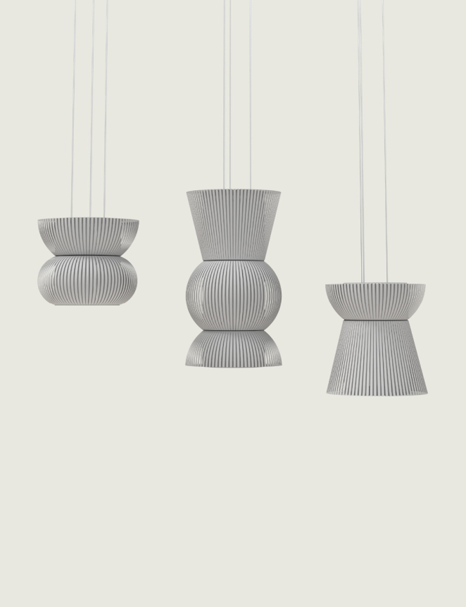 Three modern pendant lights with ribbed, gray surfaces in distinct geometric shapes against a plain background.