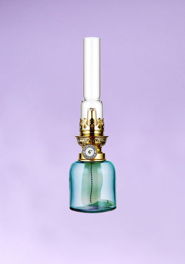 A vintage-style oil lamp with a glass base, gold detailing, and a cylindrical glass chimney against a purple background.
