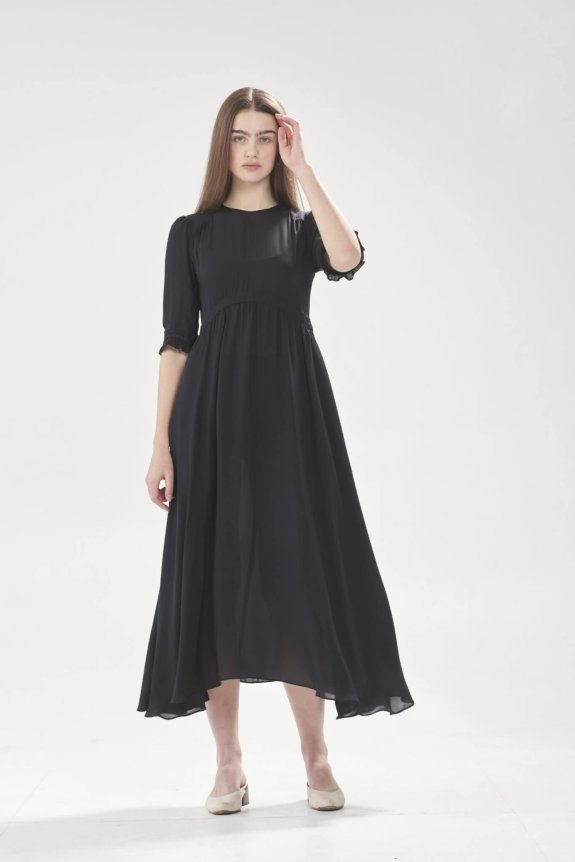A black, long-flowing chiffon dress with a semi-fitted bodice, half sleeves, and an asymmetrical hemline.