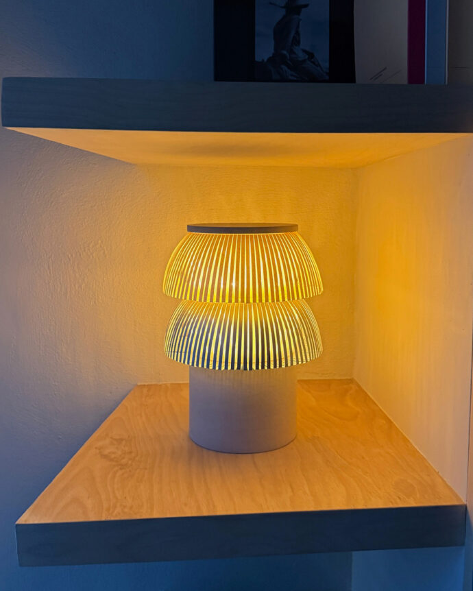 Hesperios modular paper lighting with pleated sculptural table lamp with stone base.