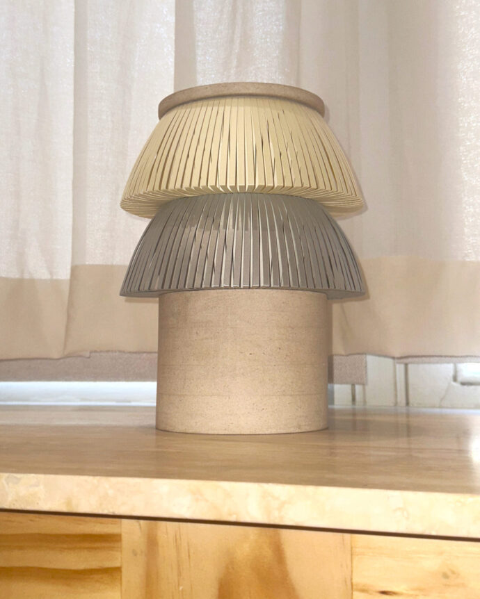 Hesperios modular paper lighting with pleated sculptural table lamp with stone base.