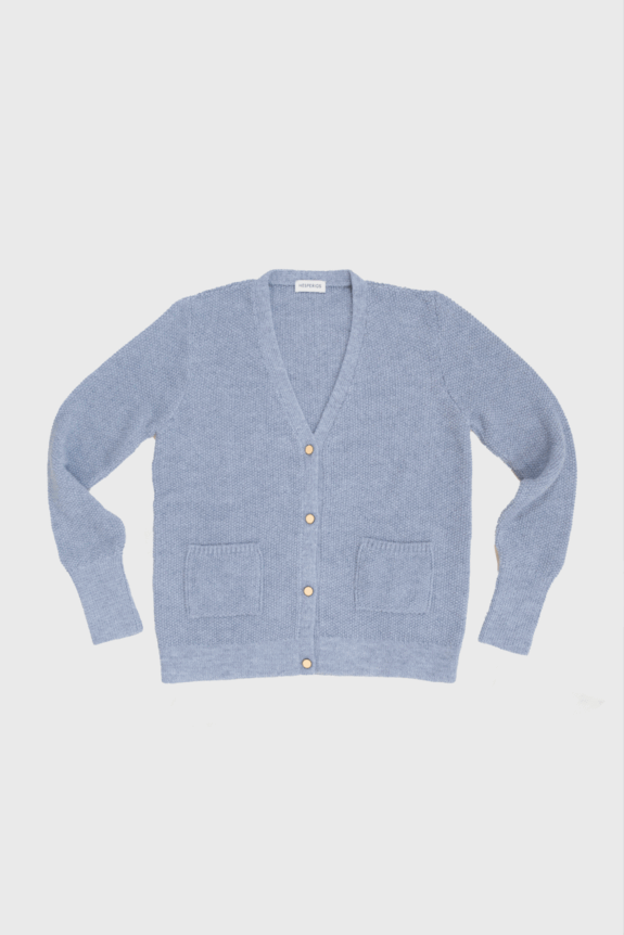 A light blue knitted cardigan with buttons and front pockets lies flat.